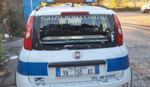 Il lunotto dell'auto di servizio della polizia locale di Roma Capitale mandato in frantumi dai colpi di carabina sparati all'interno del campo Roma -canaledieci.it