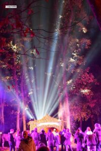 Il Presepe Vivente nel Bosco di Palo, in programma il 26 e 27 dicembre in via dei Delfini, torna a regalare emozioni con la sua 34ª edizione, confermandosi uno degli eventi natalizi più suggestivi del territorio. L’iniziativa, organizzata dalla Pro Loco in collaborazione con il Comune, si svolgerà dalle 17 alle 19.30 in un contesto naturale unico: il bosco.A rendere speciale questo presepe vivente è il percorso immersivo che si snoda interamente nel bosco, un evento unico nel suo genere. Lungo il cammino, man mano che ci si avvicina alla capanna della Natività, i visitatori incontrano 26 mestieri diversi, fedelmente ricostruiti. Tra le scene più affascinanti ci sono l’artigiano che realizza elmi, l’arrotino, la lana cardata direttamente dalla pecora, il carbonaio, il vinaio e il forno che sforna pizzette vere. Non mancano le degustazioni, con formaggio appena preparato e zuppa di ceci offerta ai presenti. I circa settanta figuranti, divisi per mestieri, non interpretano una finzione: sono artigiani veri, chiamati per mostrare antiche tradizioni e gesti autentici. A completare l’atmosfera, i fari che illuminano gli alberi del bosco e, davanti alla capanna, una suggestiva nevicata artificiale, che rende il presepe ancora più emozionante.